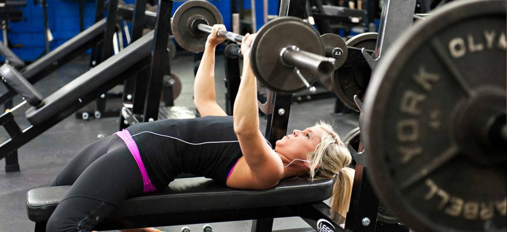 Free weight room with dumbbells, barbells, and benches for strength training at Cleveland Fitness Club